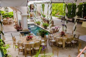 an outdoor dining area with tables and chairs and a pool at Pensativo House Hotel in Antigua Guatemala
