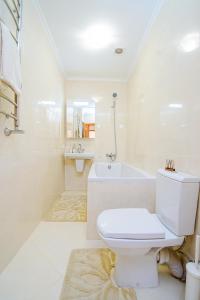リヴィウにあるEnigma apartments Lychakivの白いバスルーム(トイレ、バスタブ付)