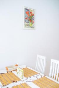 リヴィウにあるEnigma apartments Lychakivのダイニングテーブル(椅子2脚付)が備わります。壁には絵画が飾られています。