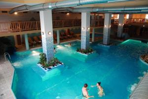 two people in a swimming pool at a hotel at Hotel Seneca in Baia Mare