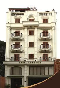 a white building with balconies on the side of it at Hotel Shwe Yee in Yangon