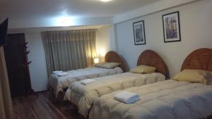 una habitación con 3 camas en una habitación de hotel en Arcopata Apartamentos, en Cusco