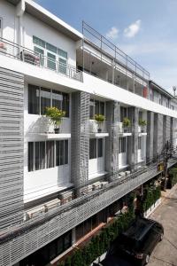 un edificio de apartamentos con macetas en los balcones en Ratchadamnoen Residence, en Bangkok