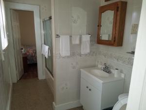 uma casa de banho branca com um lavatório e um espelho em A Sapphire Inn em Franklin