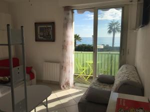 a bedroom with a balcony with a view of the ocean at Residence Acapulco in Villeneuve-Loubet