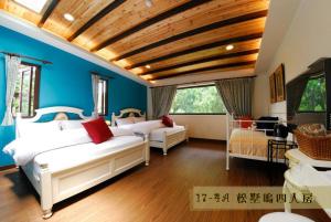 鹿谷的住宿－溪頭曼陀鄉民宿，一间卧室设有两张白色的床和蓝色的墙壁