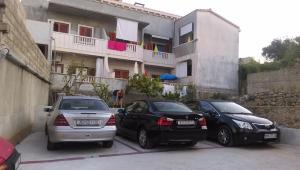 três carros estacionados num parque de estacionamento em frente a um edifício em Guest House Marija em Sumartin