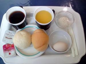 a tray of food with eggs and two cups of coffee at Business Hotel Nissei in Osaka