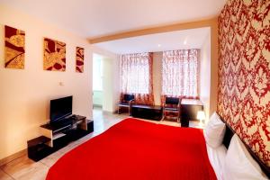 a bedroom with a red bed and a red rug at Best Apartment Plosha Rynok in Lviv