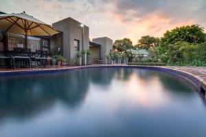 a swimming pool in front of a house at Murray Street 137 Guesthouse in Pretoria