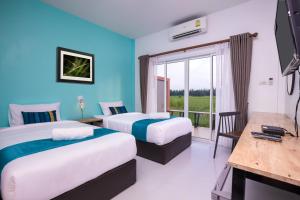 Habitación de hotel con 2 camas y balcón en Xaiyong Resort - ไทรโยงรีสอร์ท, en Buriram