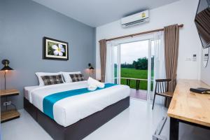 武里南Xaiyong Resort - ไทรโยงรีสอร์ท的一间带大床的卧室和一个阳台