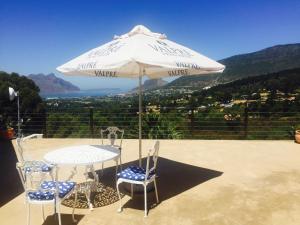 a table and chairs under an umbrella on a patio at Victorskloof Lodge in Hout Bay