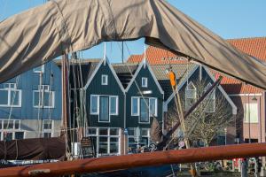 a view of a boat with houses in the background at Apartments Waterland in Monnickendam +28 photos