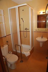 a bathroom with a shower and a toilet and a sink at ET Nocleg in Kalisz