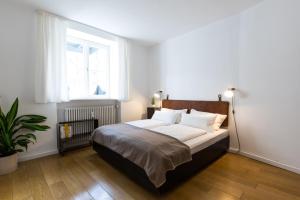 1 dormitorio con 1 cama grande y ventana en Vier Zimmer, en Múnich