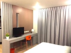 1 dormitorio con 1 cama y escritorio con TV en Live at Home Sukhumvit 105, en Bangkok