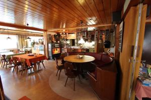 a dining room with tables and chairs and a kitchen at Hotel-Restaurant Alpina in Innertkirchen