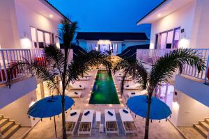 Cocotoa Boutique Hotel & Villa في غيلي تراوانغان: اطلالة على ساحة مع نخيل ومظلات