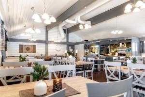 a restaurant with wooden tables and white chairs at First Camp Gol Hallingdal in Gol