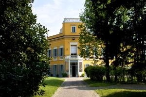 ein großes gelbes Haus mit weißem Turm in der Unterkunft Villa Lorenzo in Briosco