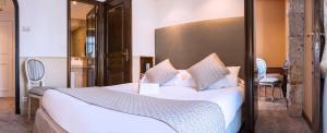 a bedroom with a large bed with white sheets and pillows at Hôtel West End Promenade in Nice