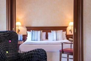 a hotel room with a bed and a chair at Hôtel West End Promenade in Nice