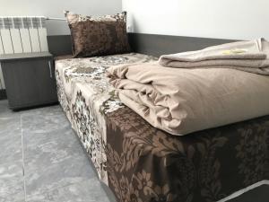 1 cama en una habitación con sofá en Hotel Rositsa en Veliko Tŭrnovo