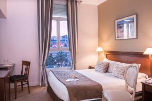 a hotel room with a bed and a window at Hôtel West End Promenade in Nice