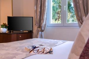 a bedroom with a tv and a bed with a box on it at Hôtel West End Promenade in Nice