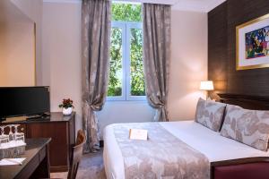 a hotel room with a bed and a window at Hôtel West End Promenade in Nice