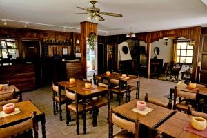 a dining room with wooden tables and chairs at Hostería Santa Bárbara in Villa Gesell