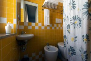 a bathroom with a sink and a toilet and a shower curtain at B&B Artemisia in Vittoria
