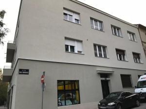 biały budynek z zaparkowanym przed nim samochodem w obiekcie Marimar apartments w Zagrzebiu