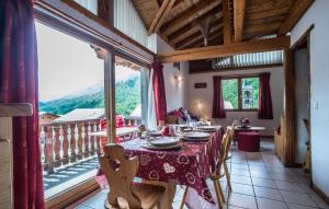 a dining room with a table and a large window at Odalys Chalet Loutantin in Saint-Martin-de-Belleville