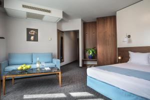a hotel room with a bed and a couch at Uniqato Hotel in Stara Zagora