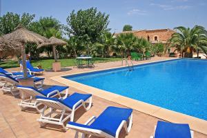a swimming pool with blue chairs and a swimming pool at Finca Son Guardiola in Llucmajor