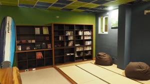 een kamer met een boekenplank met een surfplank bij 17 years old coffee hostel in Taitung