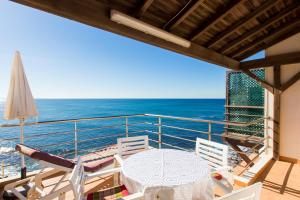 uma varanda com uma mesa e cadeiras e o oceano em Casa d'Arriba em Atouguia da Baleia