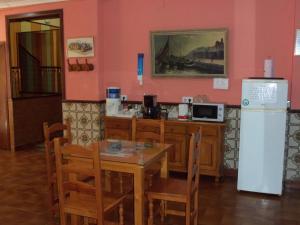 a dining room with a table and a refrigerator at La Esteponera in La Línea de la Concepción