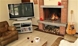 a living room with a television and a fireplace at Gardenpark Soleil in Nebbiuno