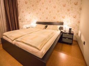 1 dormitorio con 1 cama grande y mesita de noche en Ferienwohnung am Hauskopf, en Oppenau