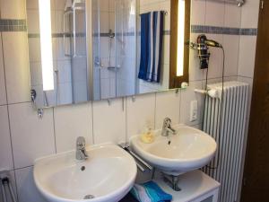 uma casa de banho com 2 lavatórios, um espelho e um chuveiro em Ferienwohnung am Hauskopf em Oppenau