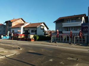 a street with buildings and umbrellas on the side of a road at Rooms Adrijana in Banja Luka