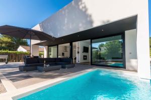 a swimming pool in front of a house at Ca Na Rosa - Modern Villa with Private Pool in Cielo de Bonaire 