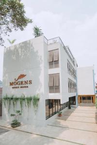 a white building with a morgans sign on it at Mogens Guesthouse in Bandung