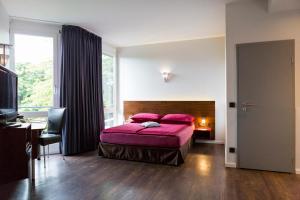 1 dormitorio con cama, escritorio y ventana en Auszeit Hotel Düsseldorf - das Frühstückshotel - Partner of SORAT Hotels en Düsseldorf