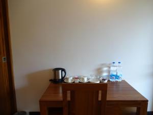 a wooden table with cups and water bottles on it at Dunhill Beach Resort in Agonda +37 photos