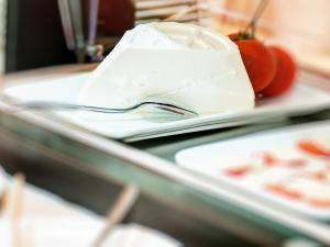 a table with a spoon and a plate of food at Hotel Ristorante La Conchiglia in Cala Gonone