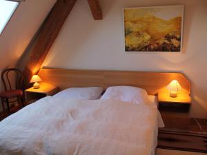 a bedroom with a white bed with two lamps at Cozy Apartment in Buschenhagen with Sauna in Buschenhagen